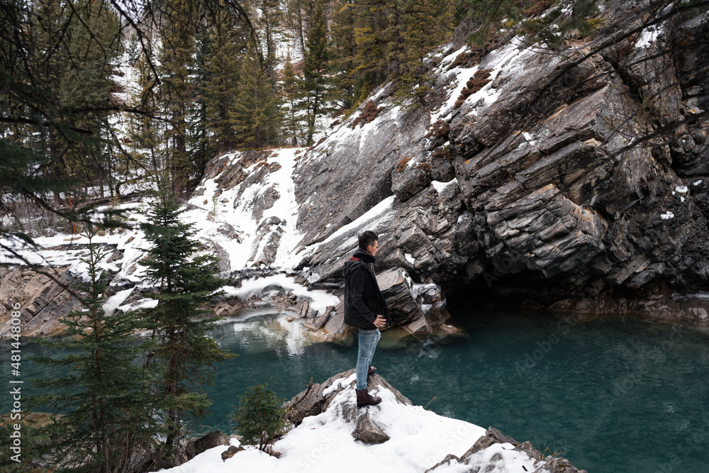 Standing on a cliff overlooking a clear river in the mountains Standing on a cliff overlooking a clear river in the mountains