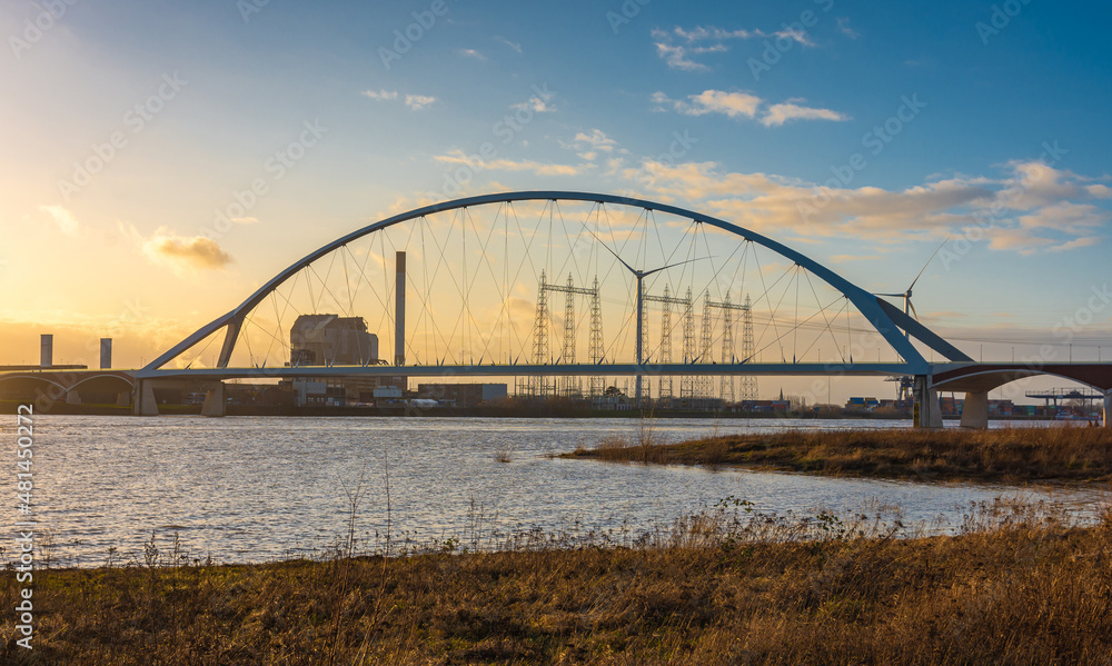 Bridge named De Oversteek (The Crossing) over the Waal river in dutch city Nijmegen by sunset