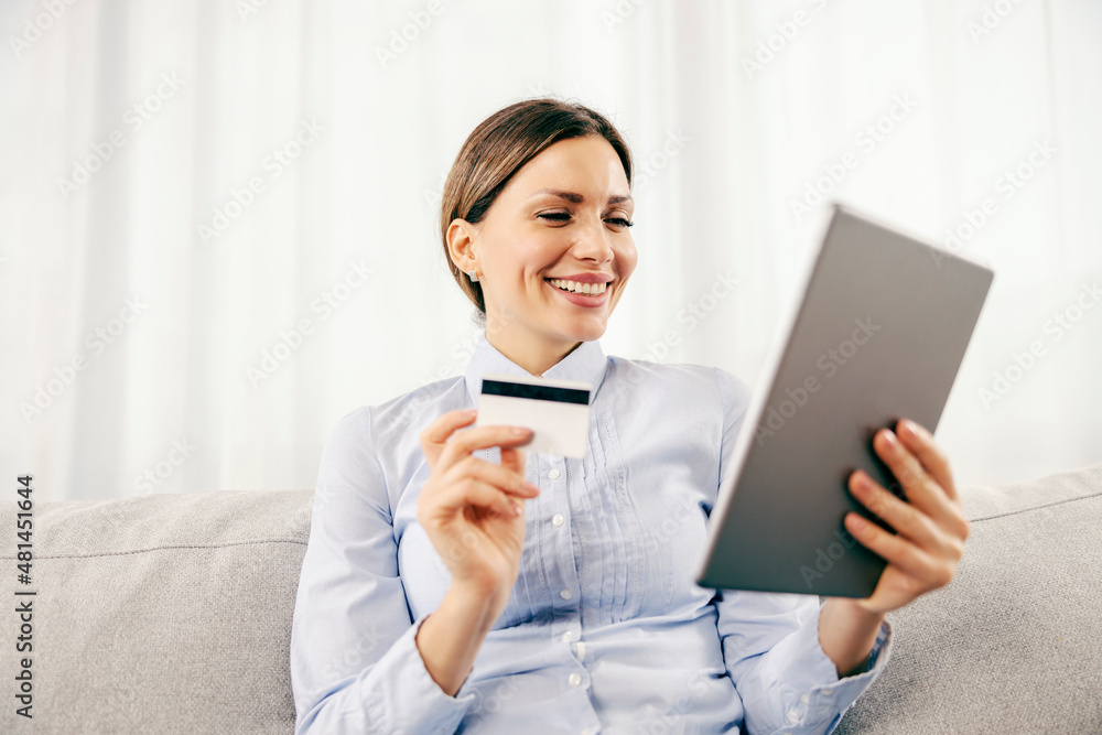 A happy woman purchasing online on the tablet. Online shopping and e-banking concept. A happy woman purchasing online on the tablet. Online shopping and e-banking concept.