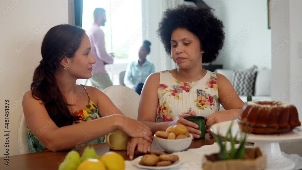 Woman talking to friend and eating at small home party. Two women smiling and having fun in afternoon gathering.
Woman talking to friend and eating at small home party. Two women smiling and having fun in afternoon gathering.