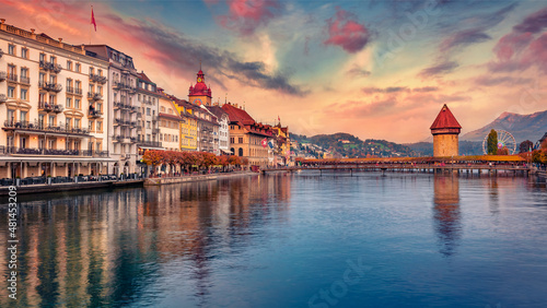 Superb autumn cityscape of Lucerne town with famous old wooden Chapel Bridge (Kapellbrucke), landmark 1300s wooden bridge with grand stone water tower decorated with 17th-century art, Switzerland.