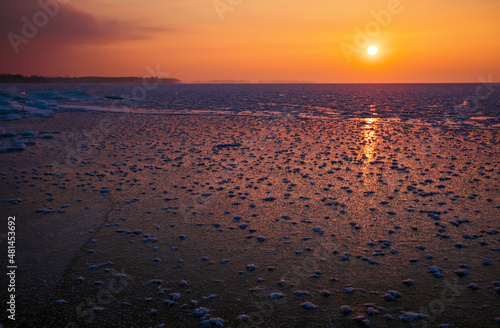 Sunrise and frozen sea. Beautiful winter landscape with lake in morning time.