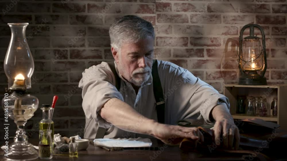 A scene from the early American pioneer era of a man preparing to disassemble his a black powder pistol in order to clean it. A scene from the early American pioneer era of a man preparing to disassemble his a black powder pistol in order to clean it.