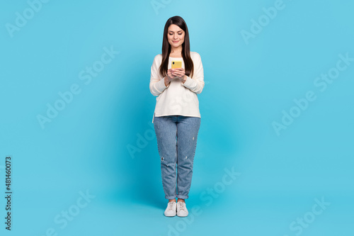 Full size photo of young pretty woman use mobile button post like comment isolated over blue color background