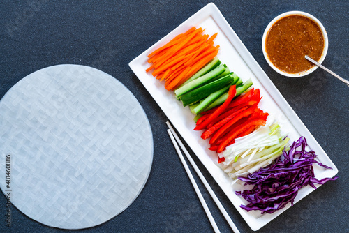 Ingredients for vegan vietnamese spring rolls with carrot, cucumber, red cabbage, spring onions and spicy sauce. Healthy eating