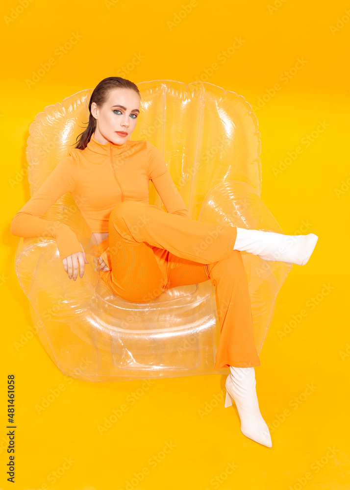 fashionable girl in bright spring clothes on an inflatable chair Stock ...