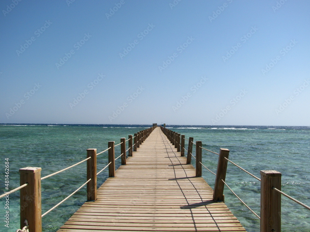 Wooden pier over a beautiful beach by the ocean