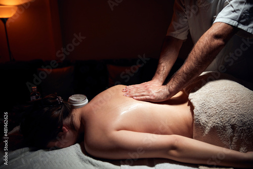 Woman on a massaging, chiropracting table, treatment of body and skin tension.