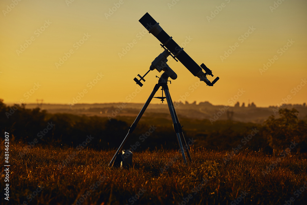 Silhouette of astronomical telescope and countryside.
