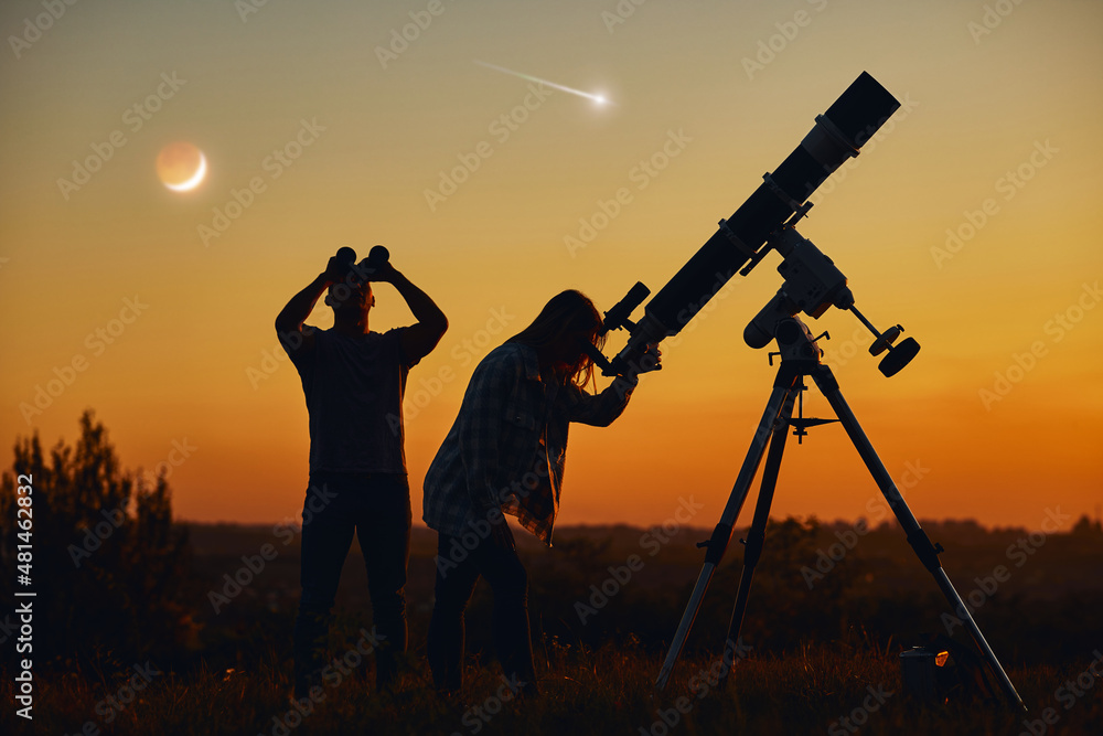 Couple stargazing together with a astronomical telescope, looking at planets, stars, lunar eclipse and meteor shower.