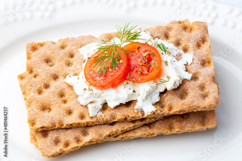 Bild auf Leinwand Fresh rye crispbread with cream cheese and vegetables isolated on white