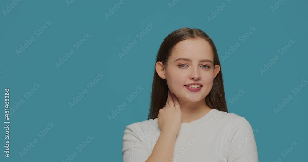 Pretty happy young girl with healthy smooth skin on blue studio background. Skincare cosmetics ad. Natural woman beauty Pretty happy young girl with healthy smooth skin on blue studio background. Skincare cosmetics ad. Natural woman beauty