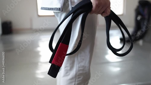 brazilian jiu jitsu bjj black belt male athlete holding belt at gym training sport self defence concept photo