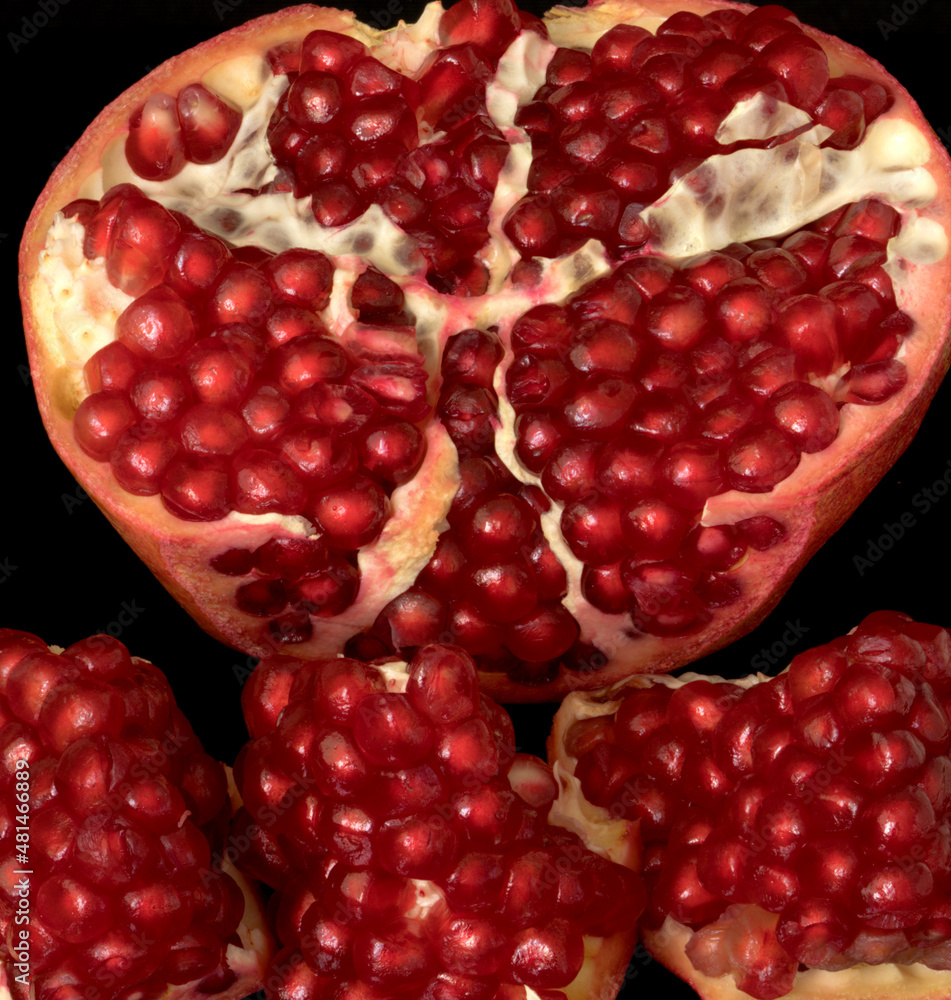 pomegranate fruit lies on a black background pomegranate fruit lies on a black background