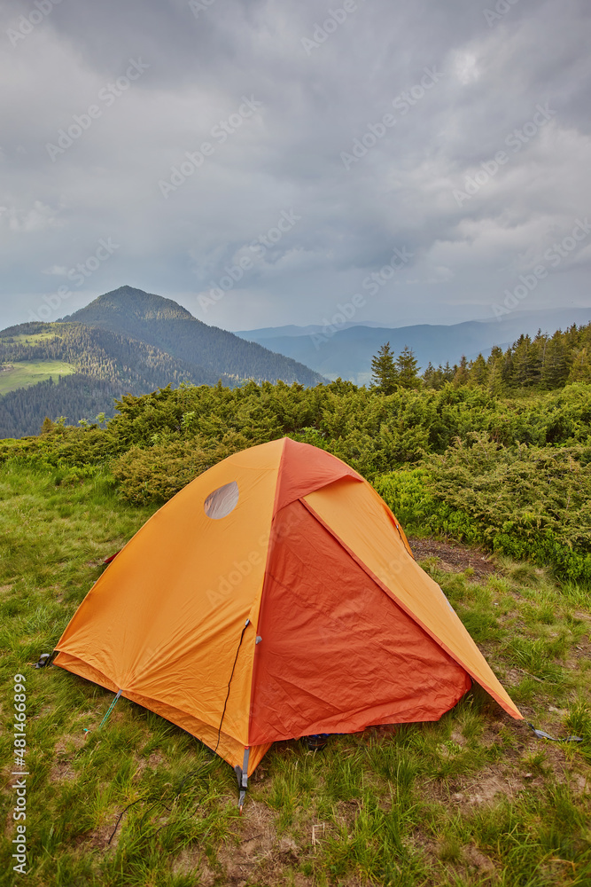 orange tourist tent in the mountains nature
