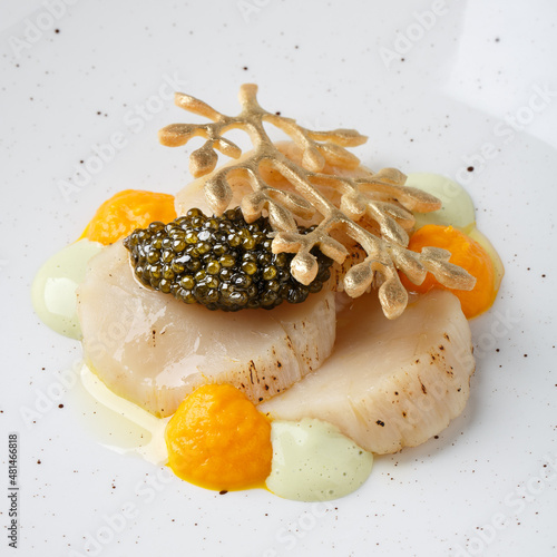 Baked scallop with black caviar.