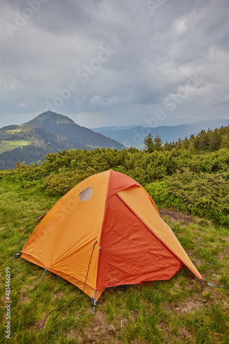 orange tourist tent in the mountains nature