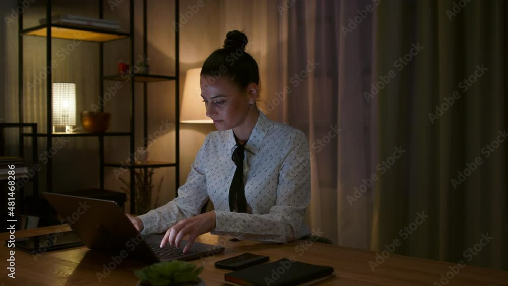 Mid adult business woman working on laptop in office at night. Mid adult business woman working on laptop in office at night.