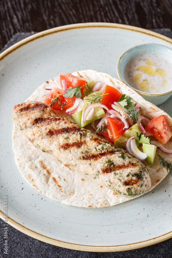Fried chicken kebab with shrimp. Served with flatbread, salad and white sauce. Fried chicken kebab with shrimp. Served with flatbread, salad and white sauce.