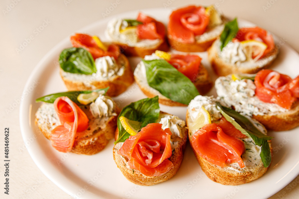 Bruschetta with salmon on a white tray.