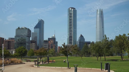 Bicentenario Park green fields with tall skyscrapers and modern skyline in background at daytime, Santiago, Chile photo