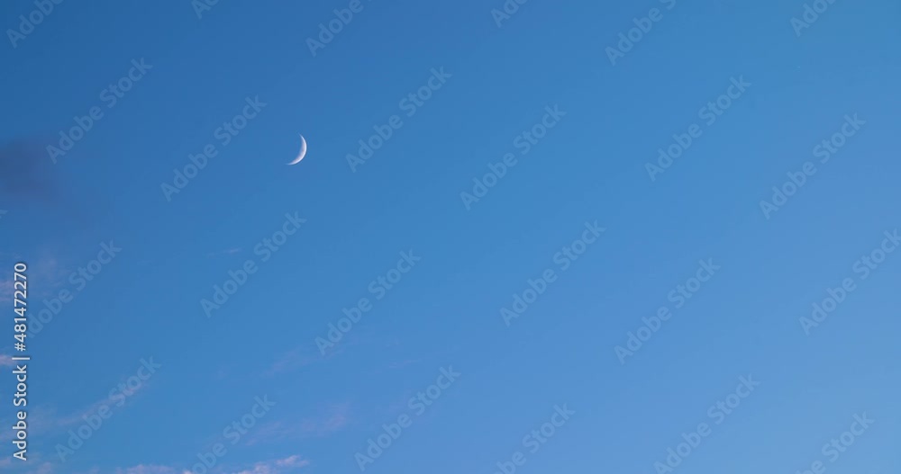 Crescent Moon in the blue sky with clouds passing by. Crescent Moon in the blue sky with clouds passing by.