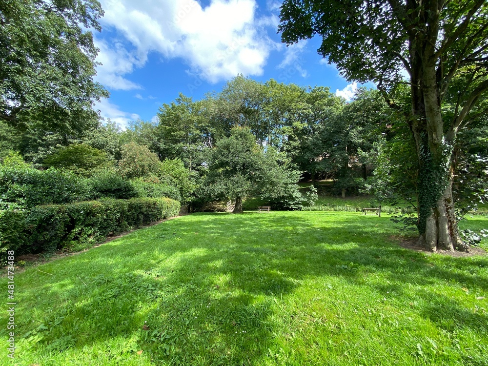 Green parkland, with wooden benches, on a sunny day in, Steeton, Keighley, UK Green parkland, with wooden benches, on a sunny day in, Steeton, Keighley, UK