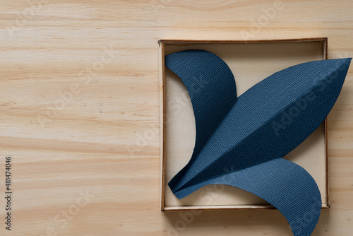 paper fleur-de-lis or fleur-de-lys shape in a box on a wooden surface photo