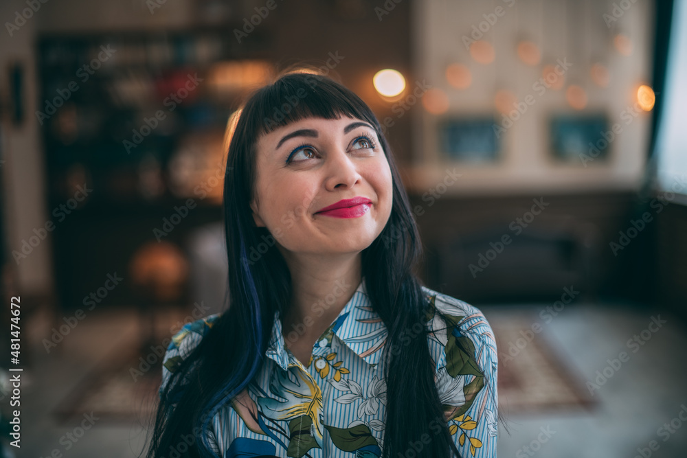 Portrait of a beautiful joyful brunette in a colorful dress in a cozy room. Fulfillment of the desires of a satisfied client. Portrait of a beautiful joyful brunette in a colorful dress in a cozy room. Fulfillment of the desires of a satisfied client.