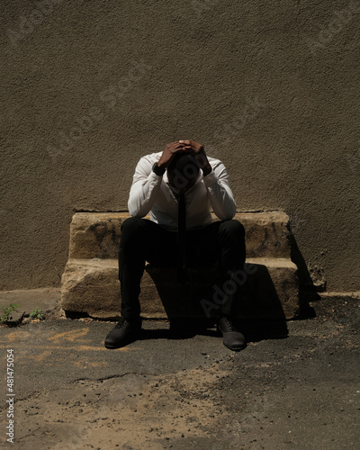 Fotografie USA, New York City, Tired businessman sitting on old stone bench outdoors