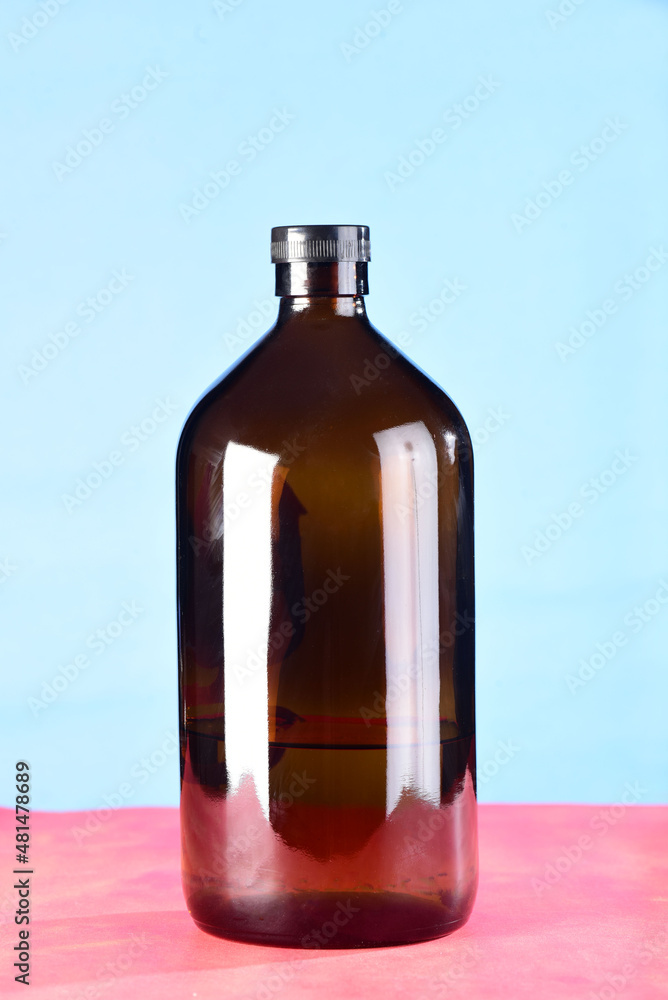 dark glass bottles isolated on blue and red background dark glass bottles isolated on blue and red background