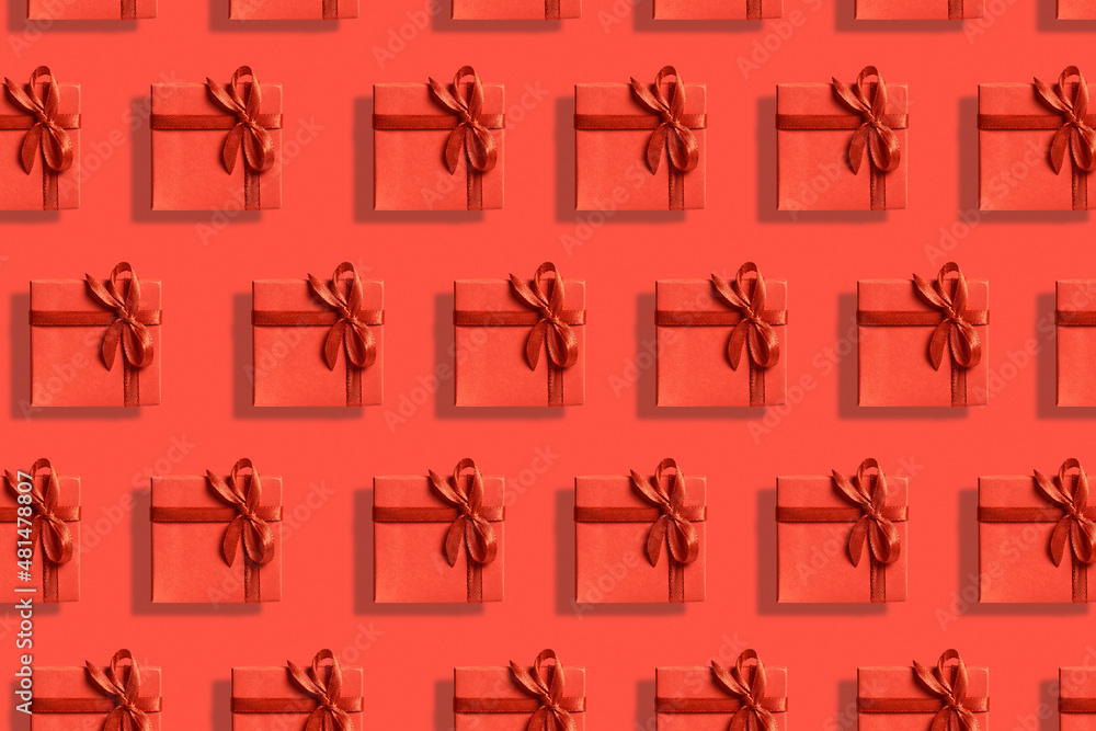 Many bright red gift boxes with ribbon on a red background. Top view