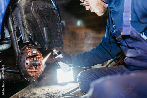 Obraz na płótnie spraying copper grease on the brake mechanism, pads and other elements of the brake system. The concept of car chemicals, car care products. w salonie