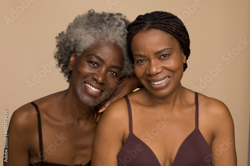 Studio portrait of two smiling women wearing lingerie