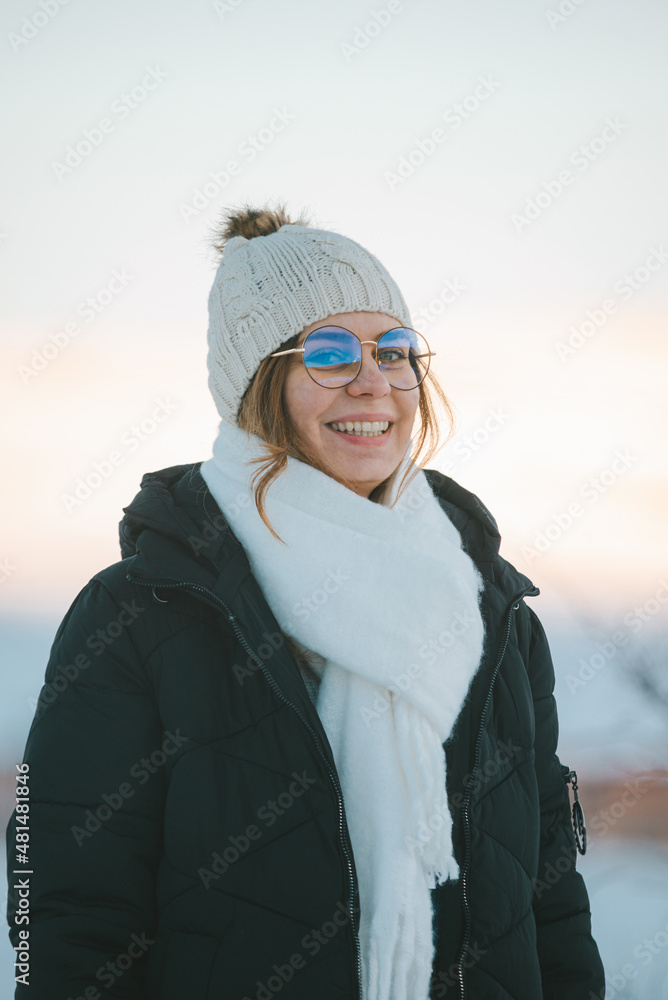 woman with hat and glasses smiling outdoors in snow woman with hat and glasses smiling outdoors in snow