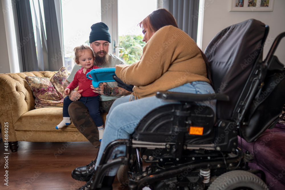Woman on wheelchair playing with family at home Woman on wheelchair playing with family at home