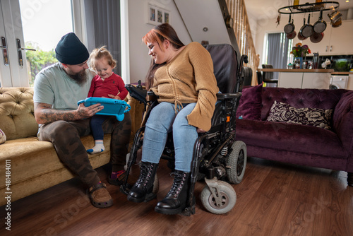 Fotografie Woman on wheelchair playing with family at home