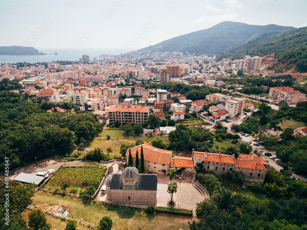 Podmaine monastery on the background of buildings. Budva, Montenegro