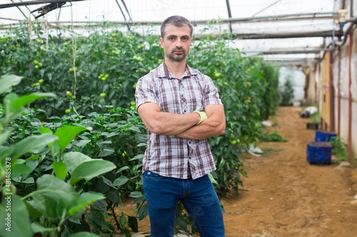 Portrait of confident farm owner with arms crossed in greenhouse