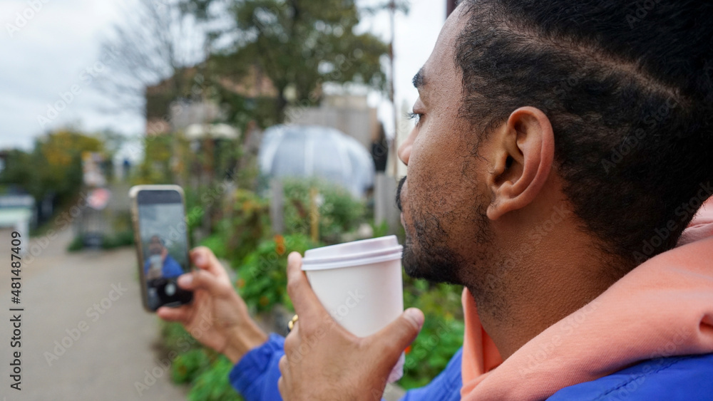 Young man holding phone and coffee Young man holding phone and coffee