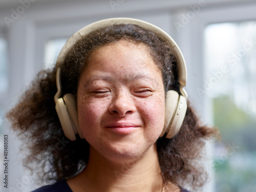 Girl with Down syndrome wearing headphones photo