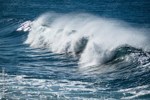Full frame shot of the deep blue Atlantic Ocean and a beautiful wave crashing on the coast of Paul do Mar, a popular surf spot on Madeira island, Portugal