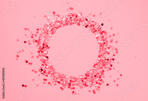 Sequins multicolored confetti lined in round frame pink background. Abstract festive composition place for text