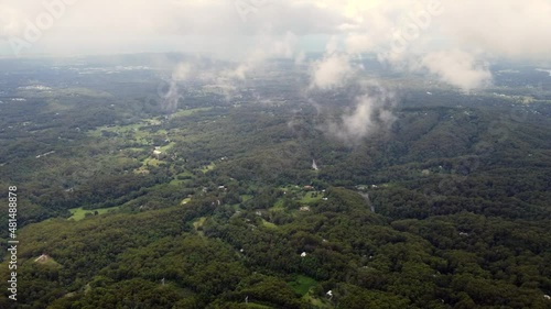 Flight over rain clouds with panorama view on valley