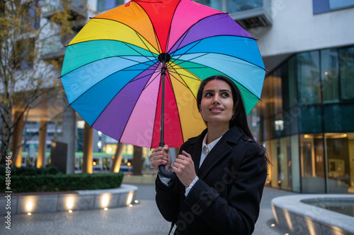 UK, London, Smiling woman holding colorful umbrella in city photo