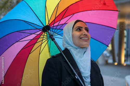 Canvas Print UK, London, Smiling woman in hijab holding colorful umbrella