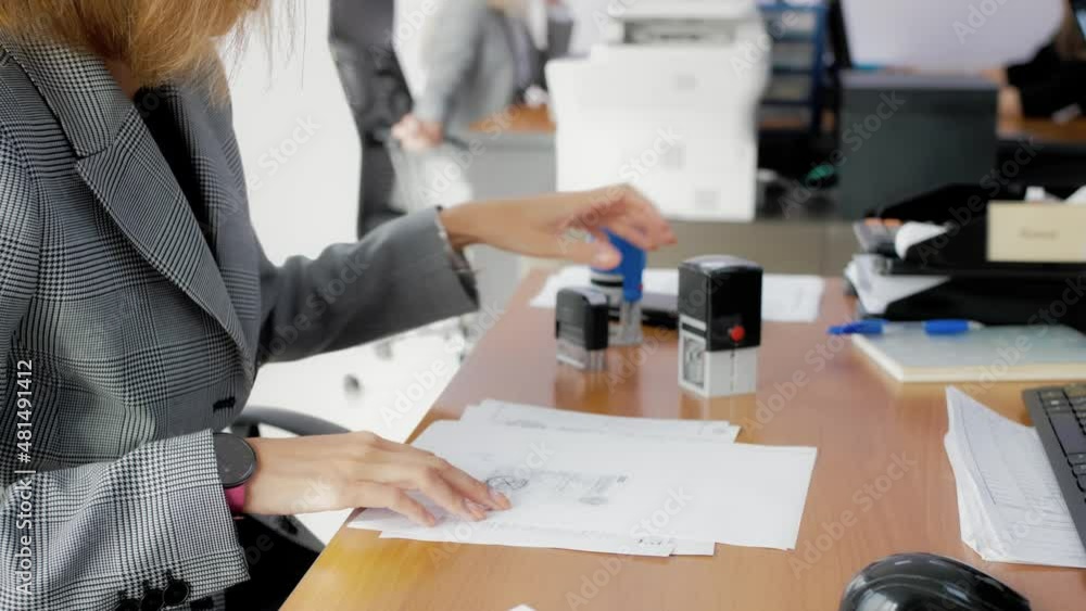 Office worker signing and stamping documents. Preparation of documents for the client. Documentation, reporting, bookkeeping, workflow Office worker signing and stamping documents. Preparation of documents for the client. Documentation, reporting, bookkeeping, workflow