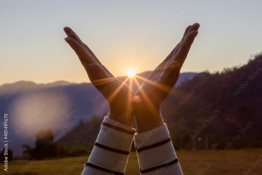 Silhouette female hands holding sun on mountain. Stock Photo | Adobe Stock