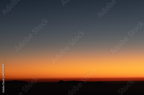 Fototapeta Naklejka Na Ścianę i Meble -  Heaven at early morning with copy space. Sunset, sunrise backdrop.Predawn clear sky with orange horizon and blue atmosphere. Smooth orange blue gradient of dawn sky.