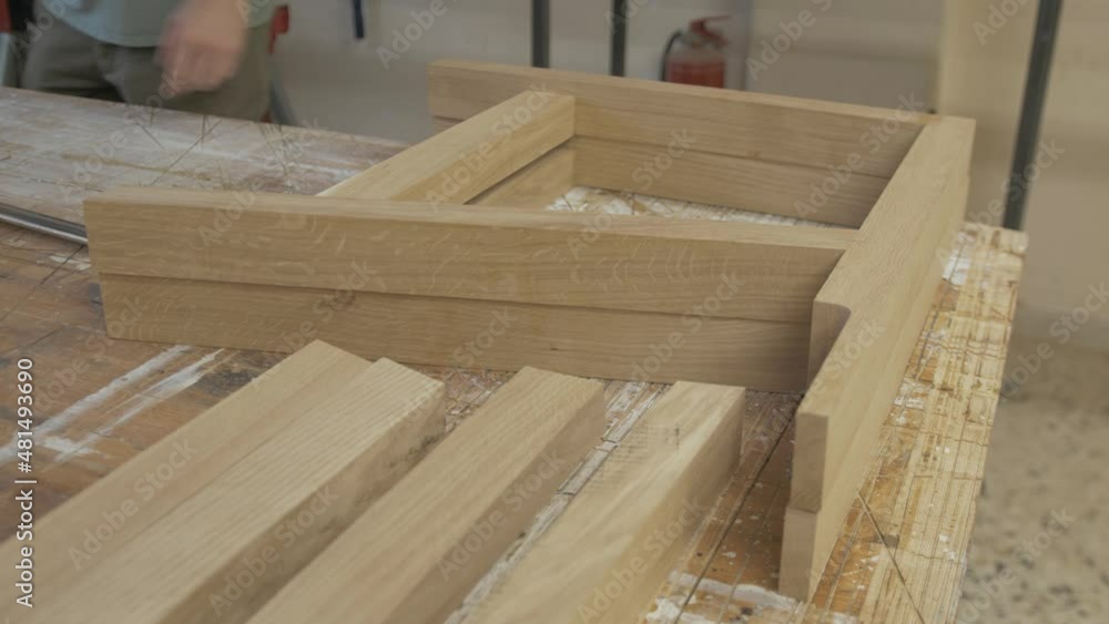 Stacking bespoke oak timber sections assembled for couch on workbench Stacking bespoke oak timber sections assembled for couch on workbench